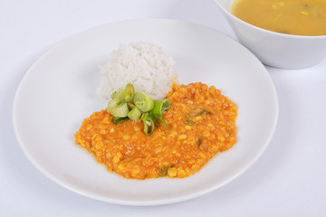 Red lentil in a sauce ansd rice on a white