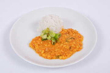 Red lentil in a sauce ansd rice on a white