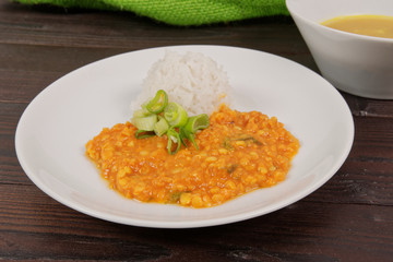Red lentil in a sauce and rice on a table
