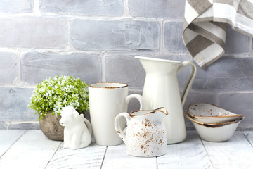 Ceramic and enamel crokery tableware agains brick wall