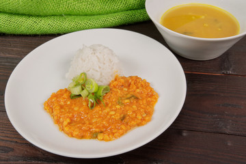 Red lentil in a sauce and rice on a table