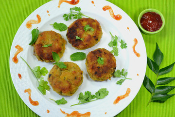 Vegetable cutlet or patties garnished with cilantro and mint leaves