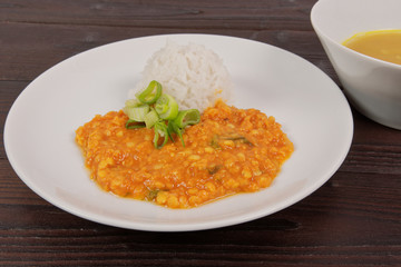 Red lentil in a sauce and rice on a table