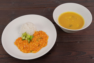 Red lentil in a sauce and rice on a table