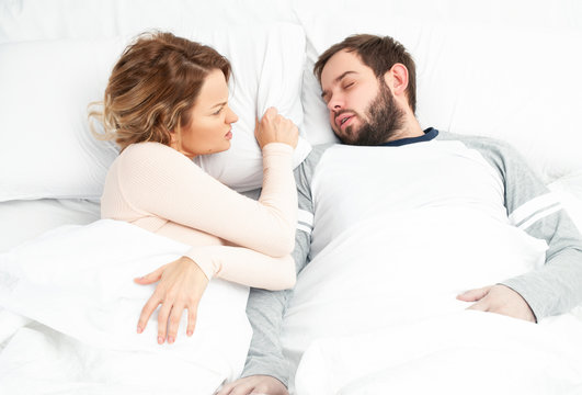 Couple in bed. Man snoring and woman can't sleep