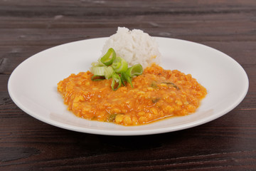 Red lentil in a sauce and rice on a table
