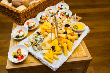 cheese on a plate on a table with salads