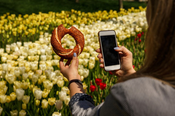 Turkish Bagel Simit, girl takes photo on smartphone traditional pastry of Turkey