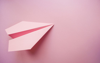 Paper plane on pink background.
