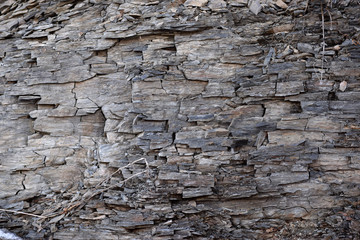 Cracked shale wall with ice and snow. 