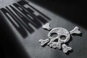 skull made of sugar, sugar crystals in the shape of a skull on a dark background, diabet shadow on it, concept about the dangers of sugar