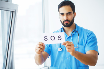 Doctor holding a card with symbol Sos, Medical concept