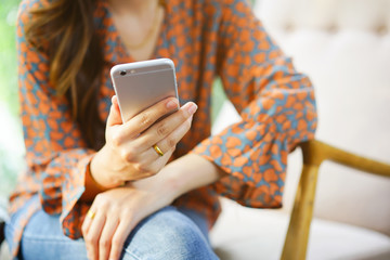 close up focus woman hand hold mobile for work or play or check alert notification on smart phone...