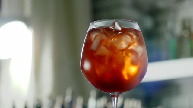 bright cooling drink with ice in large wineglass closeup on unfocused background