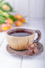 Hibiscus tea, luxury chocolates candy bunny and flowers orange tulips on a white wooden background