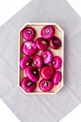 Red onion is healthy product. Onion bulbs in tray on white background top view