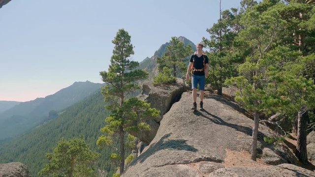 Man hiking on edge of cliff at Lake Borovoe in Kazakhstan