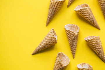 Empty waffle wafer ice cream cone on a bright yellow background
