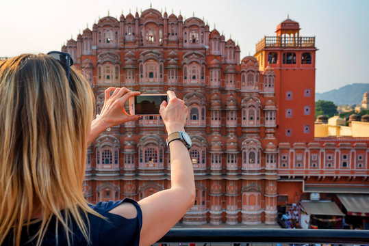 Young woman takes picture of Hawa Mahal in India