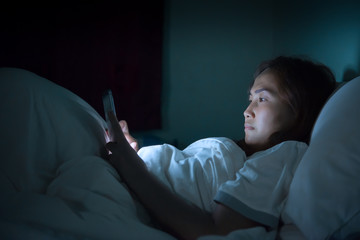 Asian woman play smartphone in the bed at night,Thailand people