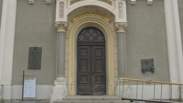 Tilt up of Trnovo Church's entrance in Ljubljana