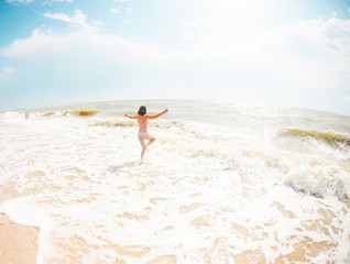 A girl is walking along the beach.