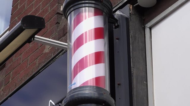 Rotating red and white barber’s pole sign.