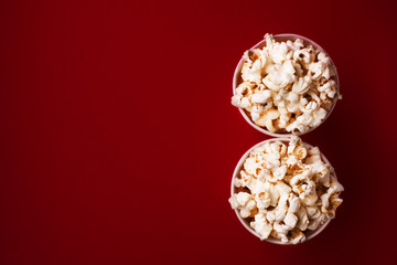 popcorn in two round boxes on a red background, top view