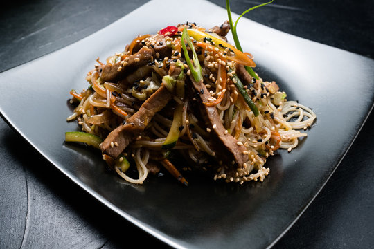 oriental cuisine restaurant food menu. noodle beef meat vegetable on a plate.
