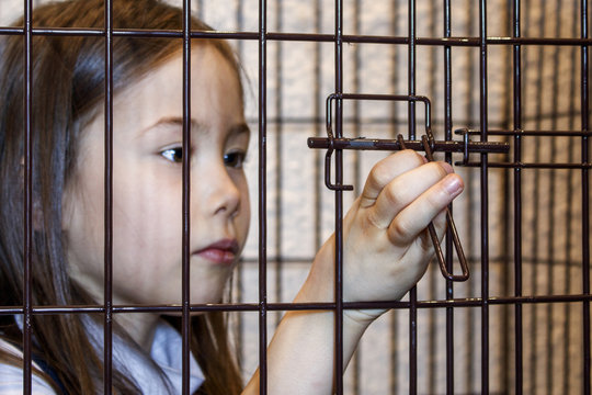 Hand of the child opening the iron cage from the inside. Exemption