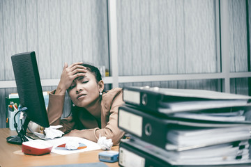 Asian woman working in office,young business woman stressed from work overload with a lot file on...