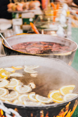 Hot fruit tea in the pots on the coals.