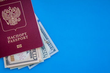 dollars in red passport on blue texture background