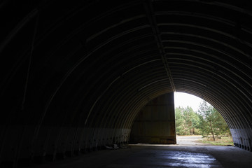  Interior of abandoned old military hangar for storage and maintenance of fighter jets and other...