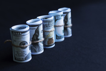 dollars in rolls on black background