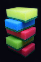 Obraz na płótnie Canvas Stack of five colorful sponges for washing dishes on black background.