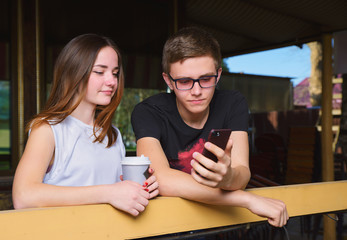 A guy with a girl in the Park and on the street with gadgets spend time together