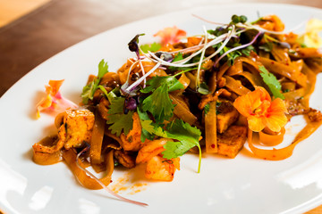 home-made noodles with chicken fried in sauce and decorated with wheat shoots