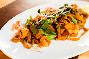 home-made noodles with chicken fried in sauce and decorated with wheat shoots