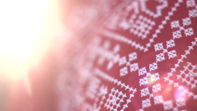 Red texture cloth embroidered with thick white thread in warm sunlight, close-up. Vyshyvanka, traditional folk ethnic ukrainian national costume. Eastern European hand embroidered shirt sorochka.