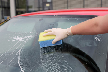 Auto serwis, mycie gąbką przedniej szyby w samochodzie osobowym,