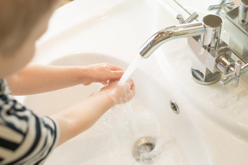 Child washes hands with soap