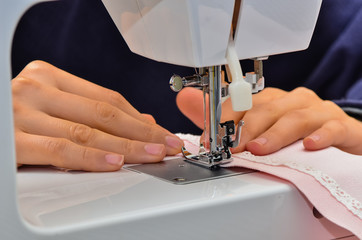 Close up sewing machine, woman is sewing a dress