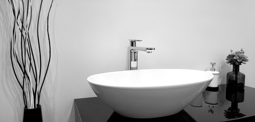 Luxury modern style faucet mixer on a white sink in a beautiful gray and white bathroom