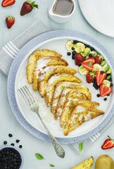 Breakfast with delicious French Toast placed with fresh strawberries,kiwi,bananas and dehydrated blueberry. served with maple syrup. Healthy food concept.