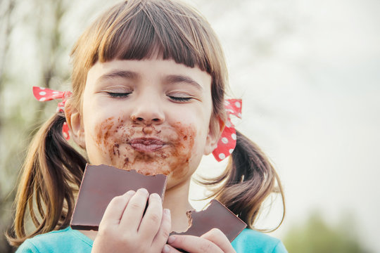 A sweet-toothed child eats chocolate. Selective focus.  