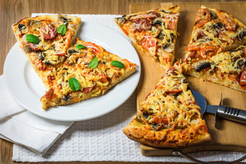Homemade fresh pizza with tomatoes, cheese and mushrooms on table closeup