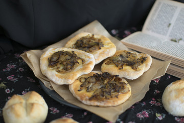 Traditional Polish onion cake. Salty cake with an onion. Fresh homemade rolls. Black background. Dark food photography. Vintage photo