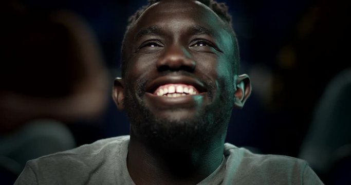 A handsome young man enjoying a movie