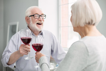 Romantic evening. Happy nice aged couple having wine while having a romantic evening together